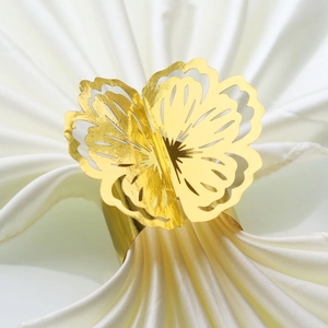 Detailed view of the golden butterfly napkin ring with intricate hollow-out carving design