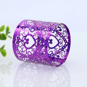Detail of purple glitter heart napkin ring with laser-cut scrollwork for weddings