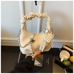 Detail of off-white hobo bag with cloud pleated handle and pearl heart charm
