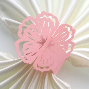 Close-up of pink laser-cut flower paper napkin ring with a subtle pearlescent shimmer finish