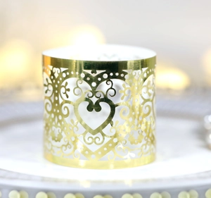 Macro detail of laser-cut golden heart cupcake wrapper with intricate patterns