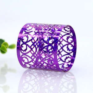 Detail of purple glitter napkin ring with intricate hollow heart and scroll patterns