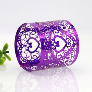 Close-up of purple glitter heart napkin ring with intricate laser-cut vine patterns