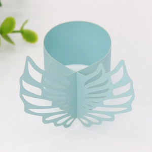 Detail of light blue laser-cut paper napkin ring with elegant hollow wing design