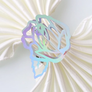 Detailed macro view of the iridescent hollow rose metal napkin ring on white silk fabric