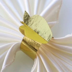 Macro shot of gold apple napkin ring on silk cloth for Thanksgiving dinner table