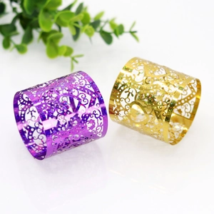 Macro detail of laser-cut heart napkin rings with glitter finish in gold and purple