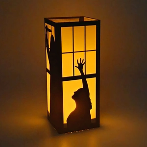 Halloween decorative paper lantern featuring spooky silhouette scenes with warm LED light