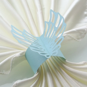 Detailed close-up of a light blue pearlescent paper butterfly napkin ring with hollow patterns