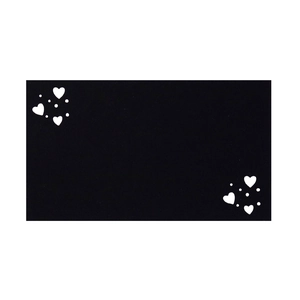 Detail of a minimalist black table card with white heart-shaped hollow patterns on corners