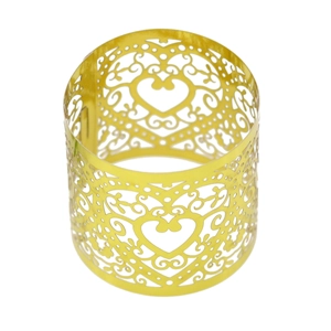 Close-up of golden hollow heart napkin ring with intricate laser-cut vine patterns