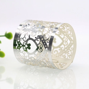 Detailed close-up of a silver heart-shaped napkin ring with intricate laser-cut floral patterns