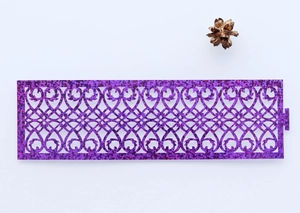Detailed macro of laser-cut purple glitter napkin ring with intricate hollow pattern