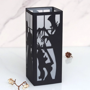 Detail of laser-cut black witch paper lantern with Halloween silhouettes and led light