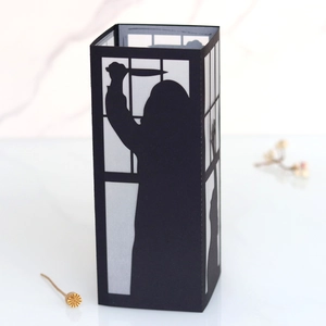 Detail of laser-cut black paper silhouette lamp featuring spooky Halloween mystery patterns