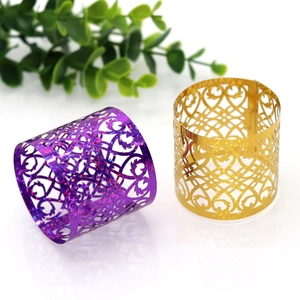 Macro detail of laser-cut napkin rings with purple and gold glittery floral patterns