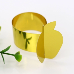 Macro shot of mirror-finish gold apple napkin ring for elegant Thanksgiving table decor