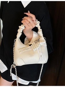 Minimalist beige crossbody bag with silver chain strap and lace bow pearl charm