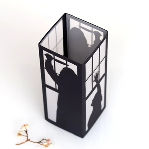 Detail of Halloween silhouette paper lantern showing spooky window scene with cut-out shadows