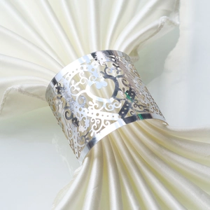 Macro shot of silver laser-cut heart napkin rings with intricate floral lace patterns