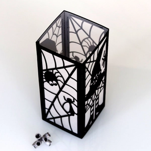 Detail of laser-cut spider web patterns on black Halloween paper lantern night light