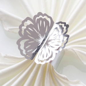 Close-up of a hollowed flower napkin ring with a polished silver finish and metal base