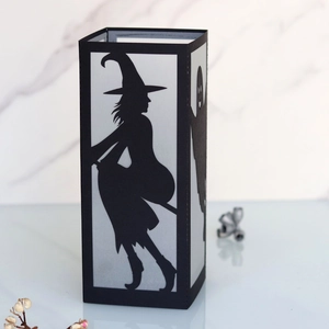 Detail of Halloween black paper lantern featuring a cutout witch silhouette on a broom
