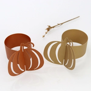Detail view of 3D pumpkin paper napkin rings in gold and orange for Halloween tables