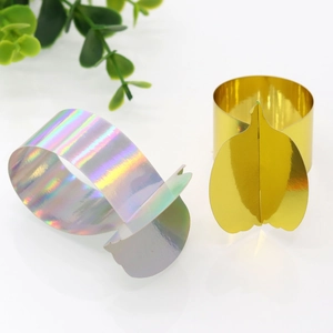 Detail of pumpkin shaped napkin ring in mirrored gold and iridescent silver finishes