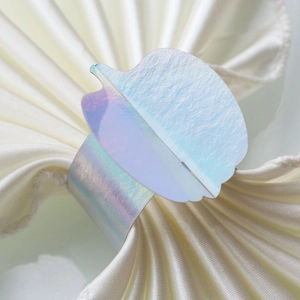 Macro shot of an iridescent pumpkin napkin ring on a beige silk cloth for table decor