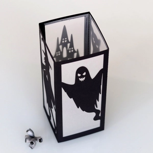 Detail of Halloween paper lantern with ghost and witch silhouettes and hollow-out carving