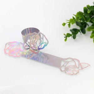 Macro detail of laser-cut rose napkin ring with iridescent finish for wedding tables