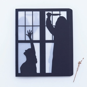 Detail of laser-cut black paper lantern showing a thriller silhouette through frosted paper