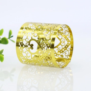 Detailed view of golden cutout napkin ring with elegant floral filigree pattern for weddings