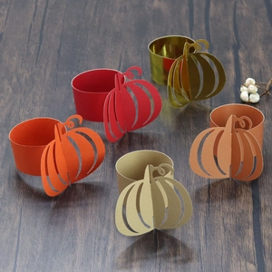 Macro detail of pumpkin paper napkin rings in autumn colors on a rustic wooden table