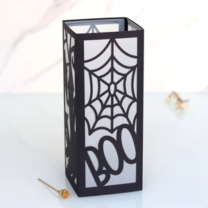 Detail of Halloween paper lantern with spider web silhouette and cutout BOO lettering