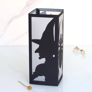 Detail of black Halloween paper lantern featuring hollowed witch and spider silhouettes