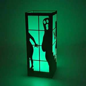 Halloween black ghost lantern with green glowing silhouettes for holiday decoration