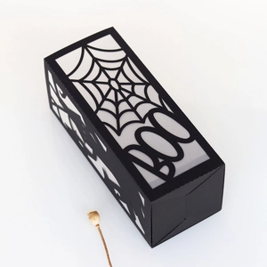 Close-up of Halloween gift box featuring hollow spider web and BOO lettering
