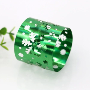 Close-up of emerald green snowflake napkin ring with metallic luster and cutout design