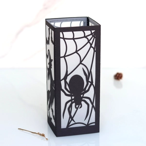 Detail of Halloween black paper lantern with spider web and witch silhouette patterns