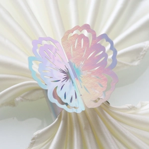 Macro view of laser-cut iridescent butterfly napkin ring with holographic finish