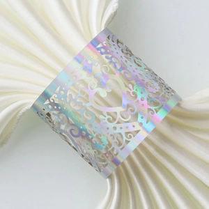 Macro detail of laser-cut heart pattern napkin ring with iridescent metallic finish