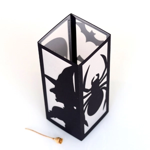 Macro shot of Halloween paper lantern with laser-cut witch, spider, and bat silhouettes