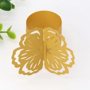 Macro shot of gold laser-cut butterfly napkin ring with intricate hollowed patterns