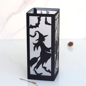 Detail of Halloween witch silhouette lantern with intricate spider web laser cut design