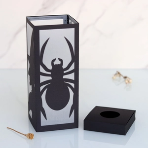 Halloween paper lantern with laser-cut spider and witch silhouettes on marble background