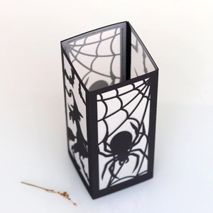Detail of Halloween paper lantern sleeve featuring laser-cut spider web and witch patterns
