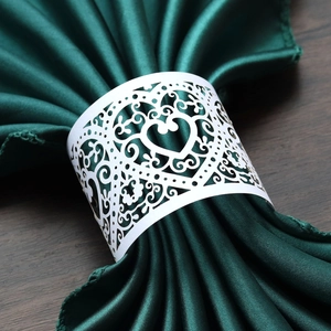 Laser-cut white heart napkin ring detail with elegant hollow floral patterns
