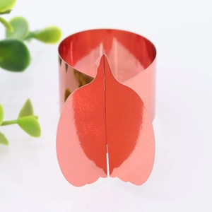Close-up of a festive red metallic napkin ring with pumpkin shape and laser-cut design